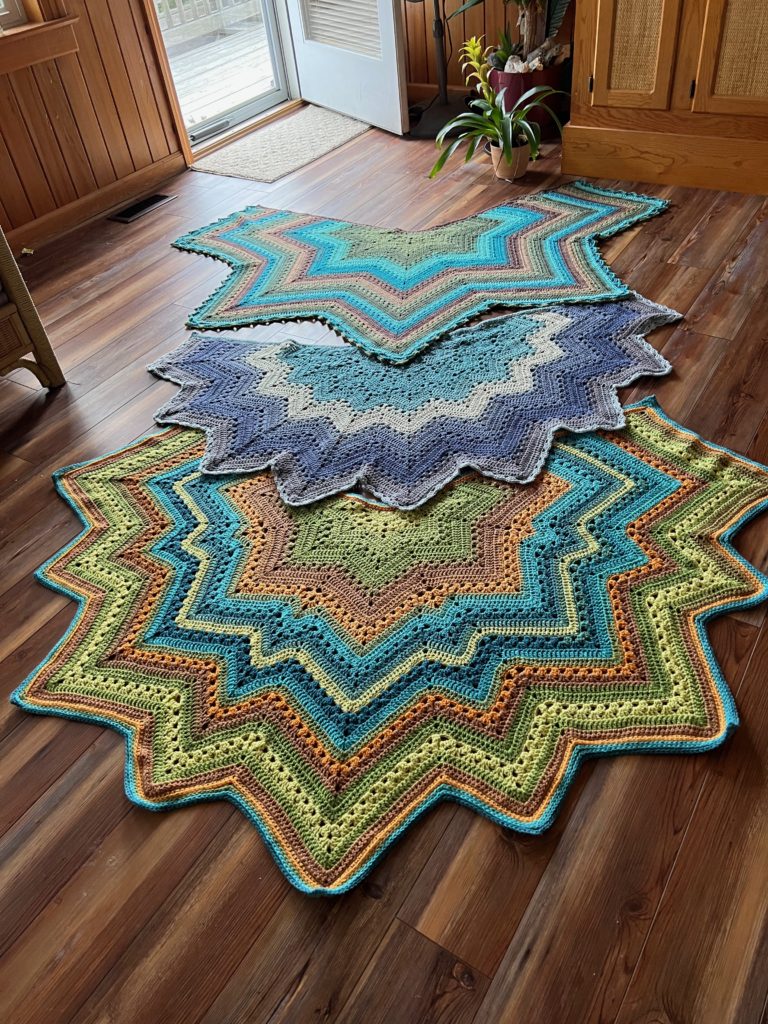 6-Day Star, Superstar, and Supernova Shawls shown in Lion Brand Mandala Yarns.