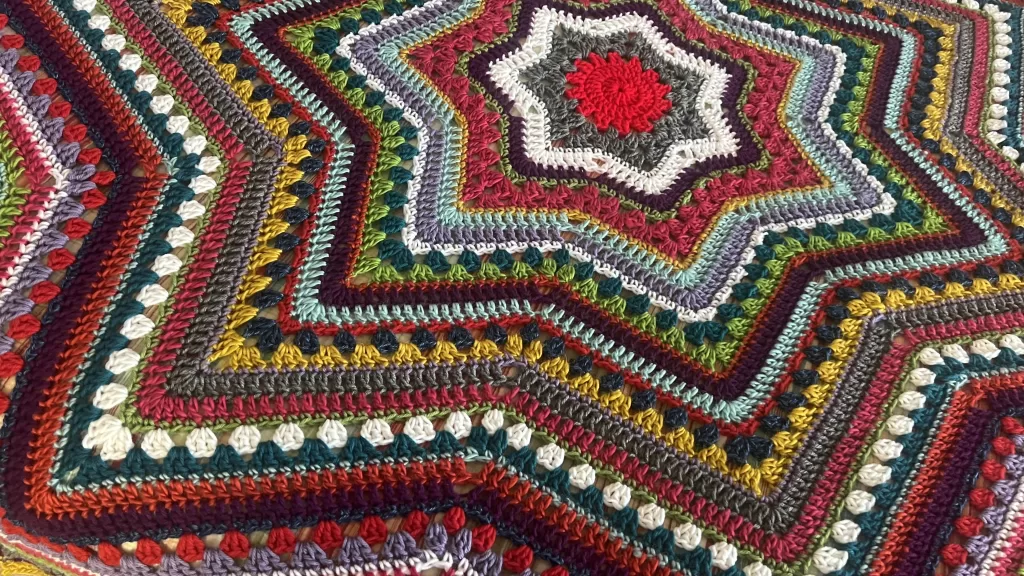 Colorful 6-Day Star Blanket in red, white, gold, blue, and green