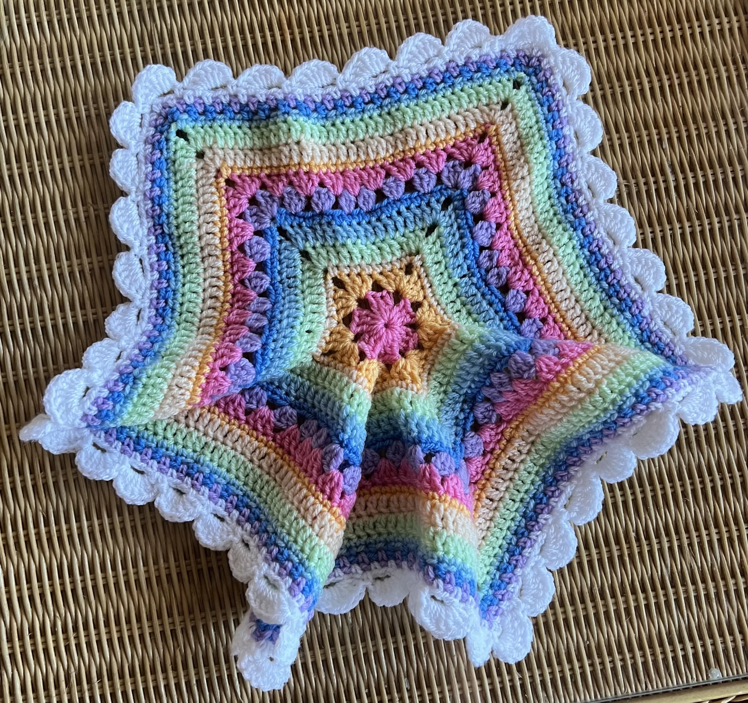 small star shaped blanket with soft rainbow colors and scalloped edge