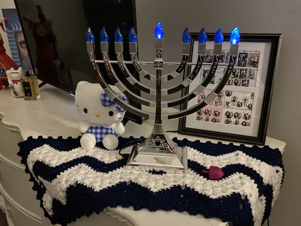 Holiday menorah with table runner, hello kitty, and personal items displayed