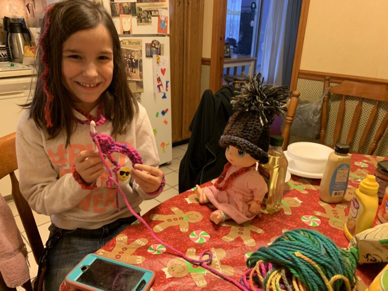 Young crocheter shows off her projects