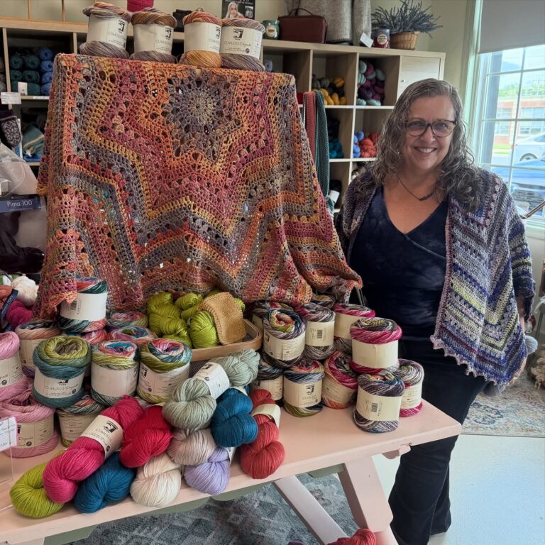 Betty McKnit with Juniper Moon Farm display at Mother of Yarns