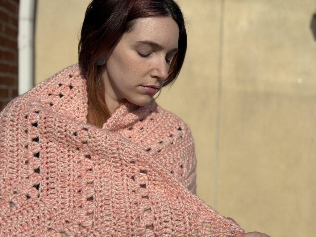 Woman modeling pink crochet shawl